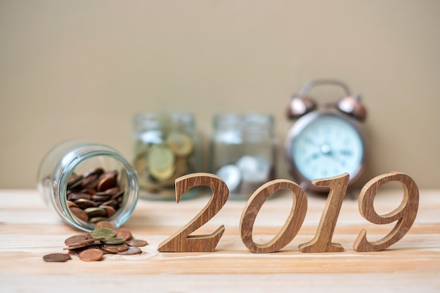 Foto 2019 happy new year con pila di monete d'oro e numero di legno