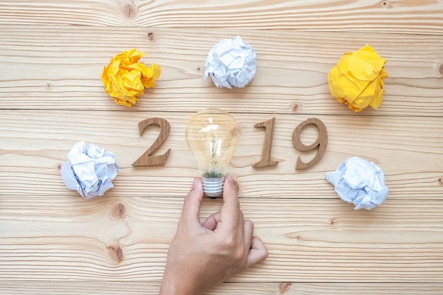 2019 Happy New years with Businessman holding lightbulb 