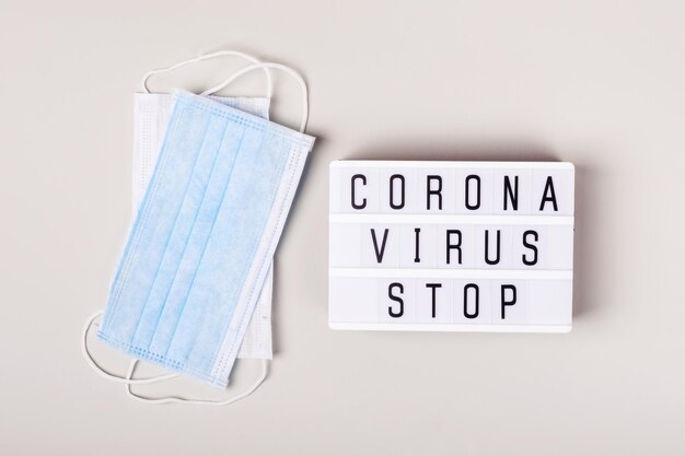 2019-nCoV Coronavirus originating in Wuhan, China. Medical mask and lightboard with words Coronavirus stop. treatment concept.