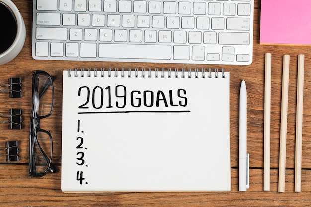 2019 new year goal,plan,action text on notepad with office accessories.