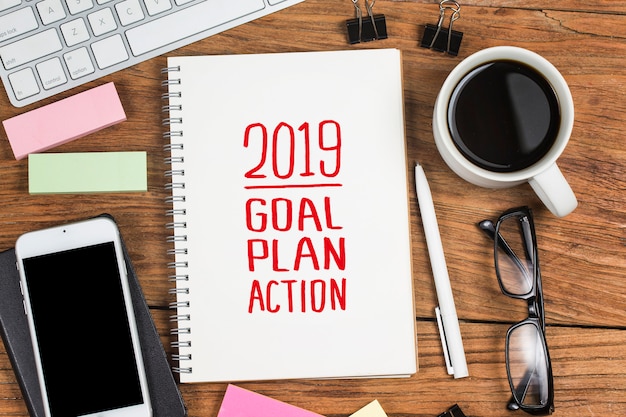 2019 new year goal,plan,action text on notepad with office accessories.