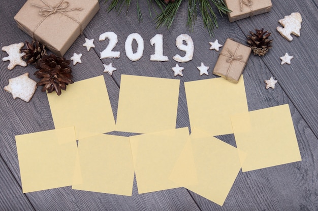 2019 номеров из печенья с подарками, ель, сосна на деревянном фоне. Новый год. Пожелания