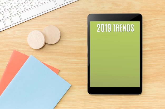 2019 trends on green screen tablet with notebook and keyboard on table