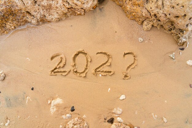 202 handwritten on sandy beach