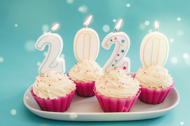 Photo 2020 candles on cupcakes with whip cream frosting using pink silicone reusable cups