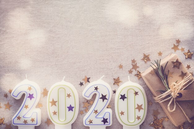 2020 candles with eco present boxes, Happy New Year decoration, fairy light toning background