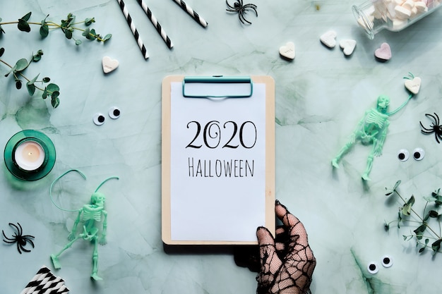 2020 Halloween-tekst op klembord in de hand gehouden.