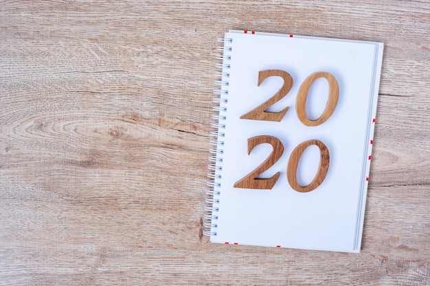2020 Happy New years with blank notebook for text and wooden number 