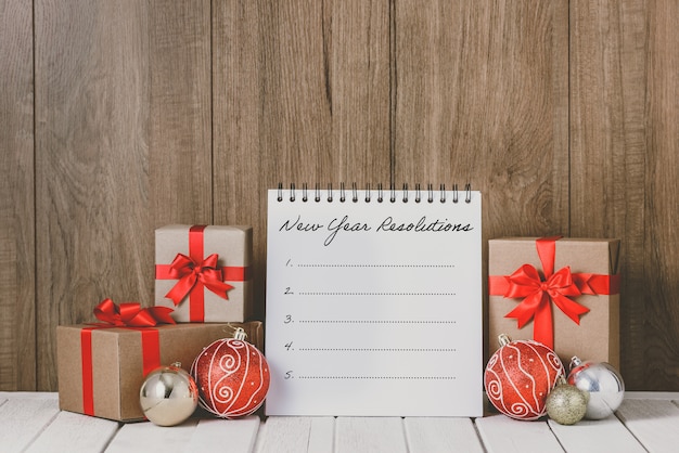 2020 houten tekst met kerstversieringen en Nieuwjaarsresolutielijst geschreven op notebook over houten