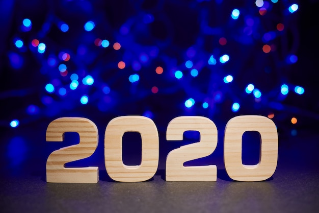 2020 wooden letters on blue bokeh lights. 