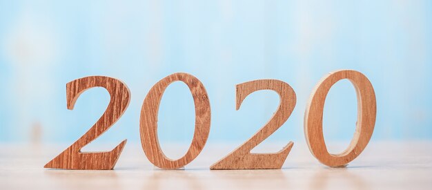 2020 wooden number on blue table background with copy space for text. 