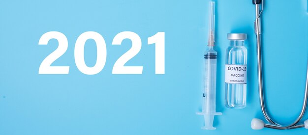 2021 gelukkig nieuwjaar met covid-19 vaccin flacon en injectie naaldspuit tegen coronavirus