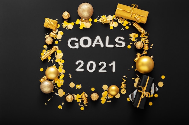 2021 Goals text lettering on black surface in frame made of gold Christmas festive decor