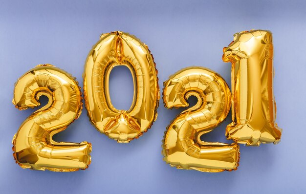 Photo 2021 happy new year gold air balloons text in line on violet background