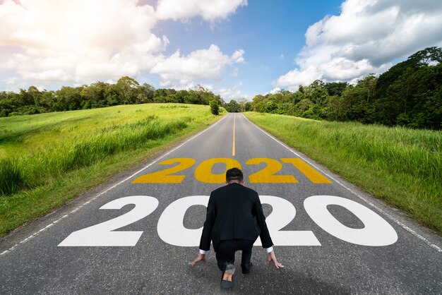 Il viaggio del capodanno 2021 e il concetto di visione futura. uomo d'affari che viaggia su una strada autostradale che porta alla celebrazione del felice anno nuovo all'inizio del 2021 per un inizio fresco e di successo.