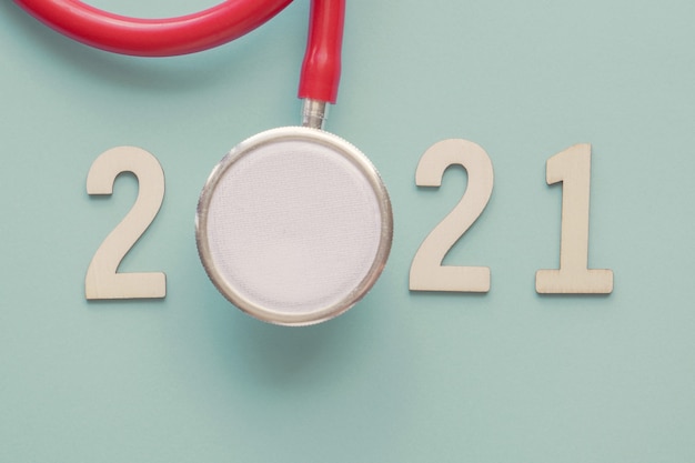 Photo 2021 wooden number with red stethoscope. happy new year health resolutions