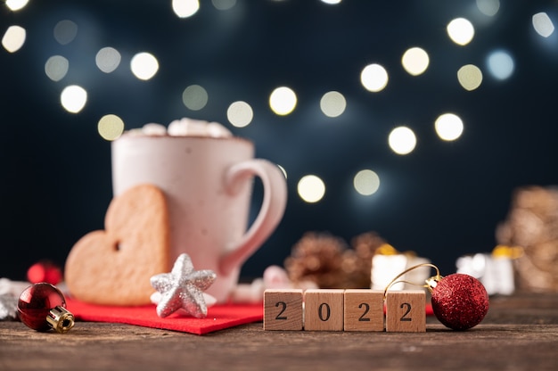 2022-bord geplaatst naast een feestelijke setting van warme chocolademelk gegarneerd met marshmallow-snoepjes