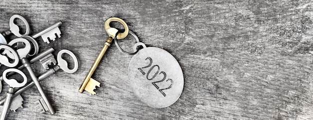 Photo 2022 engraved on a ring of an old key on wooden background