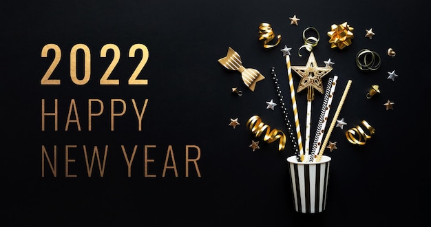 Foto 2022 gelukkig nieuwjaar, feest en feest met gouden prop en ornament op donkere kleur achtergrond. plat lag ontwerp