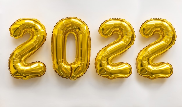 Photo 2022 gold numbers inflatable figures numbers on white background. the concept of new year and christmas