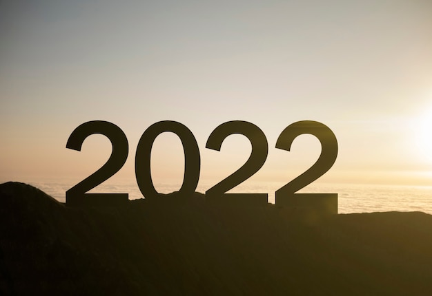 A 2022 happy new year sign on top of the mountain with sunset, symbol of new success and opportunities