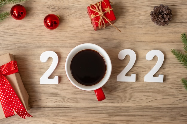 2022 happy new year with coffee cup and christmas decoration on\
wood table background. new start, resolution, countdown, goals,\
plan, action and mission concept