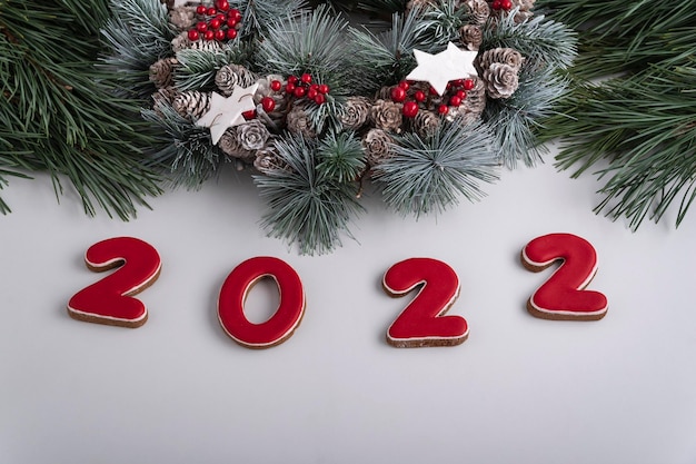 2022 inscriptie en kerstkrans, bovenaanzicht. witte achtergrond. gelukkig nieuwjaar 2022