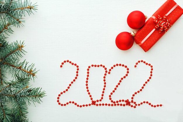 白い背景の上のプレゼントギフトボックスで幸せな新年のクリスマスの構成をレタリング2022