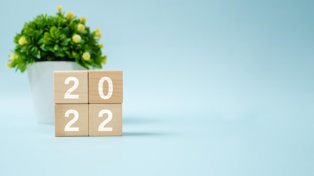 2022 new year greeting card template, 2022 on wooden cubes on wood table, banner with copy space for text