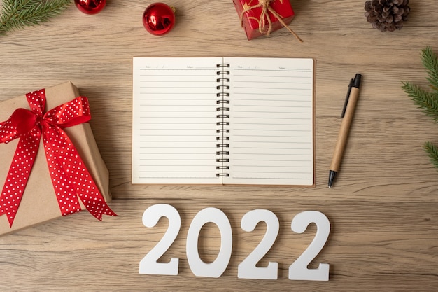 2022 New Year with notebook, Christmas gift and pen on wood table. Xmas, Happy New Year, Goals, Resolution, To do list, start, Strategy and Plan concept