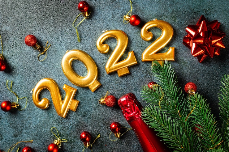 Photo 2022 number with champagne bottle and decor. happy new year and festive concept. top horizontal view, copyspace. new year flatly. christmas flatlay. new year 2022. new year concept.