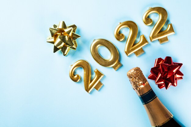 Foto numero 2022 con bottiglia di champagne e decorazioni. felice anno nuovo e concetto festivo. vista orizzontale dall'alto, copyspace. anno nuovo piatto. piatto di natale. nuovo anno 2022. concetto di nuovo anno.