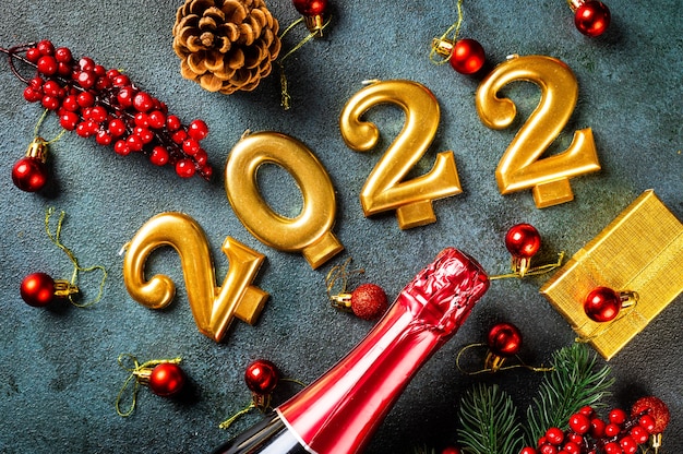 シャンパンボトルと装飾が施された2022年の番号。明けましておめでとうとお祝いのコンセプト。上部の水平方向のビュー、コピースペース。明けましておめでとうございます。クリスマスフラットレイ。新年2022年。新年のコンセプト。