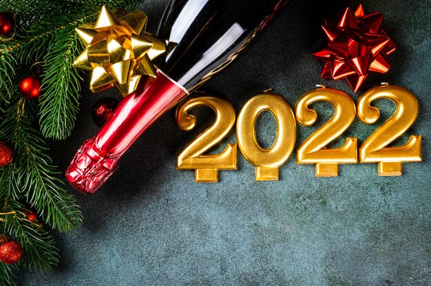 Foto numero 2022 con bottiglia di champagne e decorazioni. felice anno nuovo e concetto festivo. vista orizzontale dall'alto, copyspace. anno nuovo piatto. piatto di natale. nuovo anno 2022. concetto di nuovo anno.