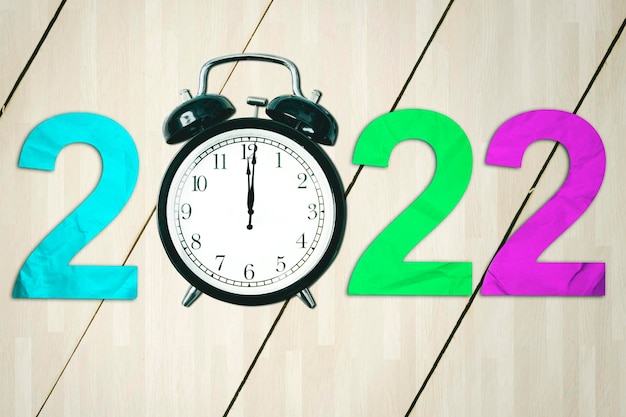 木製テーブルの上に目覚まし時計が付いた 2022 年の数字