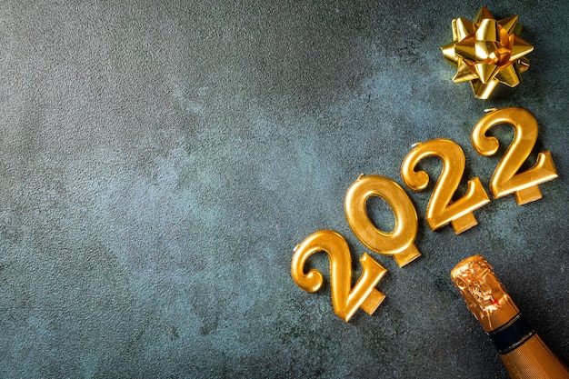 Foto 2022 nummers met champagnefles en decor. gelukkig nieuwjaar en feestelijk concept. bovenste horizontale weergave copyspace. nieuwjaar plat. kerst flatlay. nieuw jaar 2022. nieuw jaarconcept.