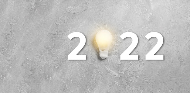 2022 одна подвесная лампочка на сером бетонном фоне. Успешная бизнес-идея и творческая концепция инноваций. Плоская планировка, вид сверху, копия пространства
