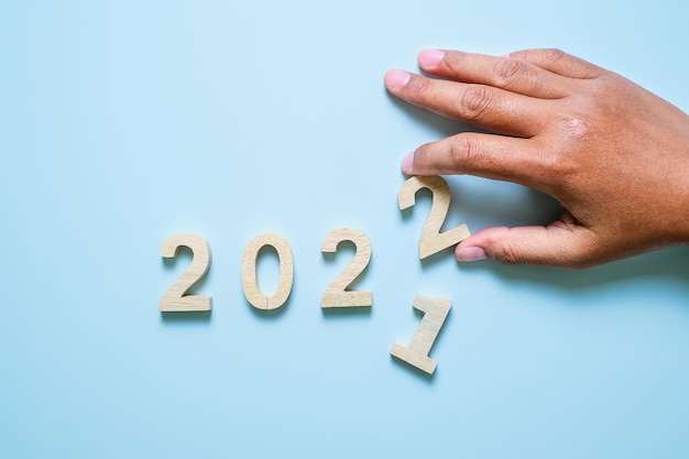 青い背景に2022年の木製のテキスト番号。解決、計画、レビュー、目標、開始、年末年始の概念
