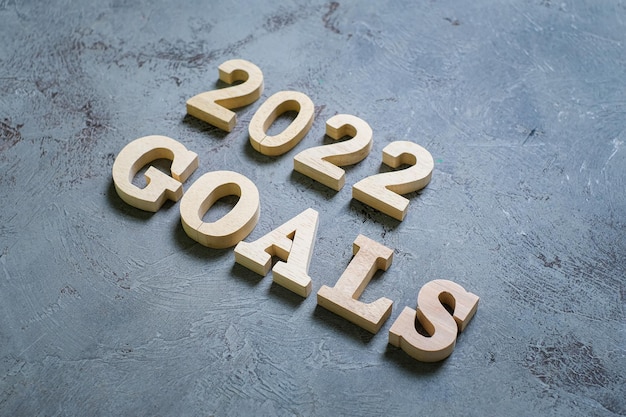 灰色の背景に2022年の木製のテキスト番号。解決、計画、レビュー、目標、開始、年末年始の概念
