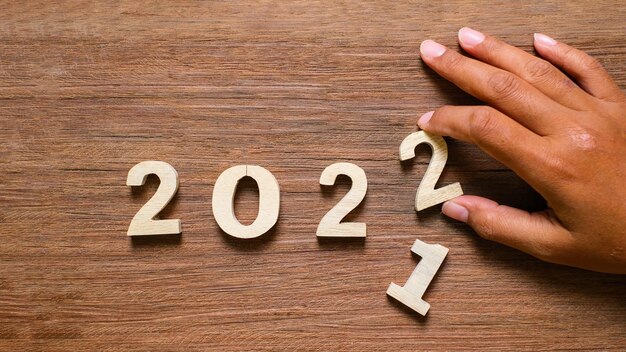 写真 木製の背景に2022年の木製のテキスト番号。解決、計画、レビュー、目標、開始、年末年始の概念