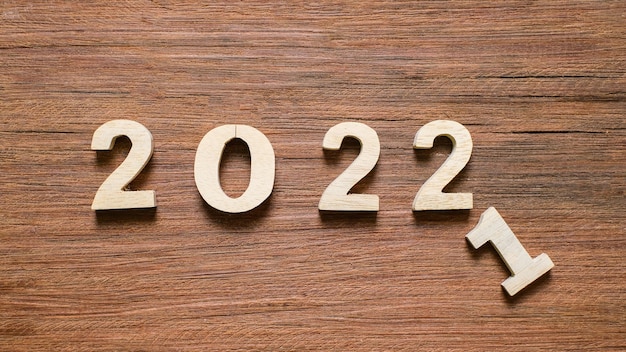 나무 배경에 2022 나무 텍스트 번호입니다. 해결, 계획, 검토, 목표, 시작 및 새해 휴일 개념