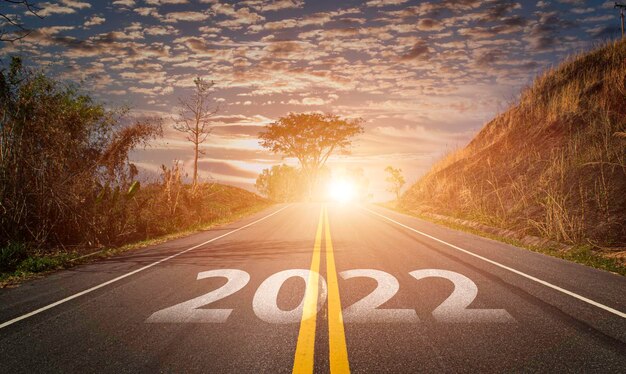 高速道路で書かれた2022年。空のアスファルト道路と美しい日の出の空の背景。 2022年のビジョンの目標と挑戦の概念。