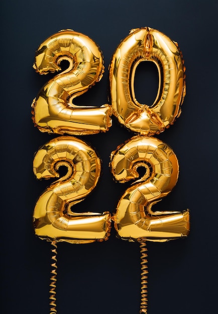 Photo 2022 year balloon gold text on black background with golden ribbons happy new year eve invitation