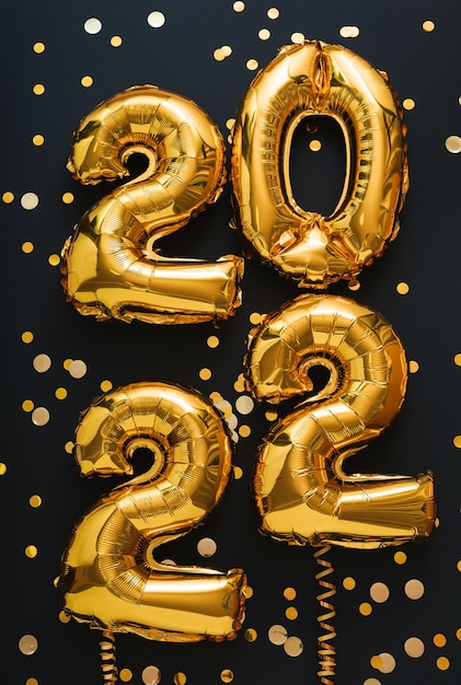 Фото 2022 год золотой шар на черном фоне с золотыми лентами праздничное конфетти с новым годом