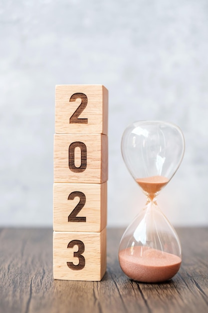 2023 block with hourglass on table Resolution time plan goal motivation reboot countdown and New Year holiday concepts