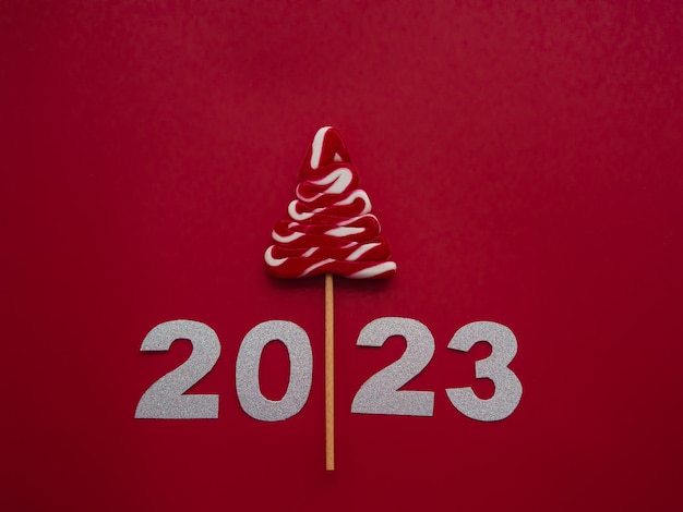 2023 en wit rood snoep in de vorm van een kerstboom op een rode achtergrond