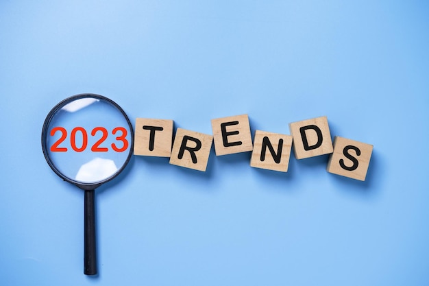 2023 jaar binnenkant vergrootglas met trends formulering op blauwe achtergrond voor marketing monitor en business schaven focus verandering concept