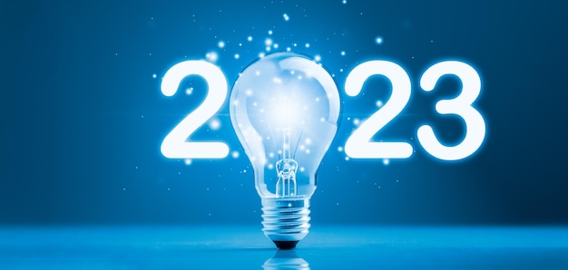 Foto lampadina 2023 con effetto scintillante di luce incandescente. concetto di 2023 obiettivi, idee, obiettivi, affari