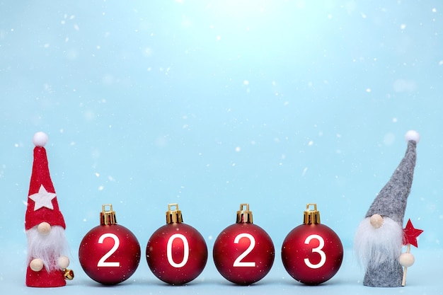 2023 年新年の背景。今年の数字と小さなノームのクリスマス ボール