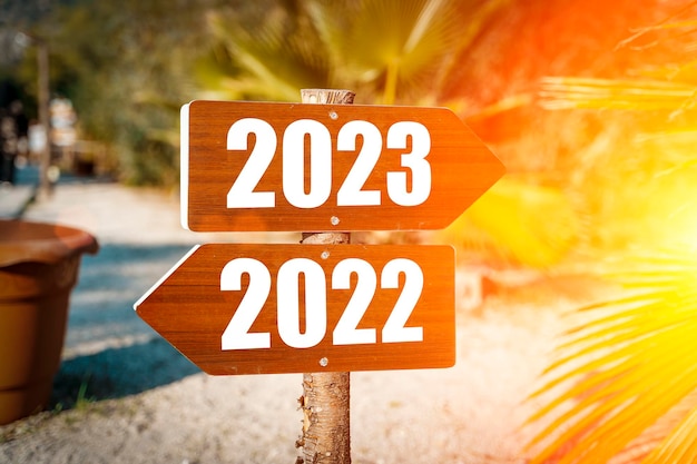 2023年の新年のコンセプト日当たりの良い熱帯の夏のビーチで2023年の新年の方向性を持つ道標楽観的なポジティブな目標